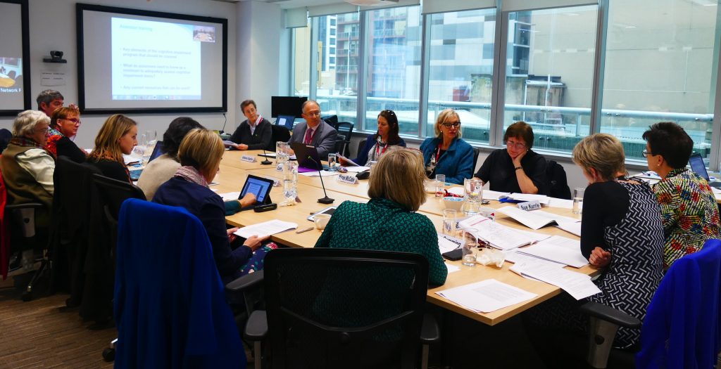 Members of the advisory group are sat around a board room table